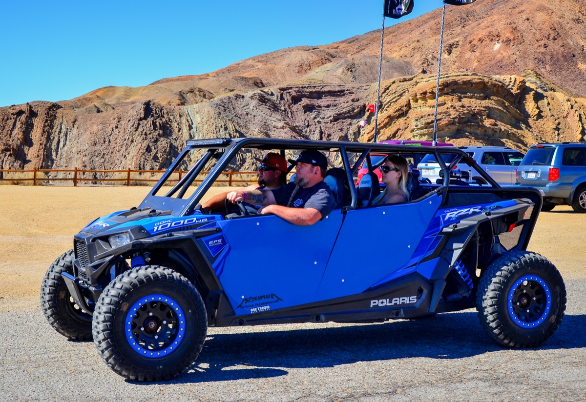 Driver and passengers in a side-by-side buggy on a guided off-road tour