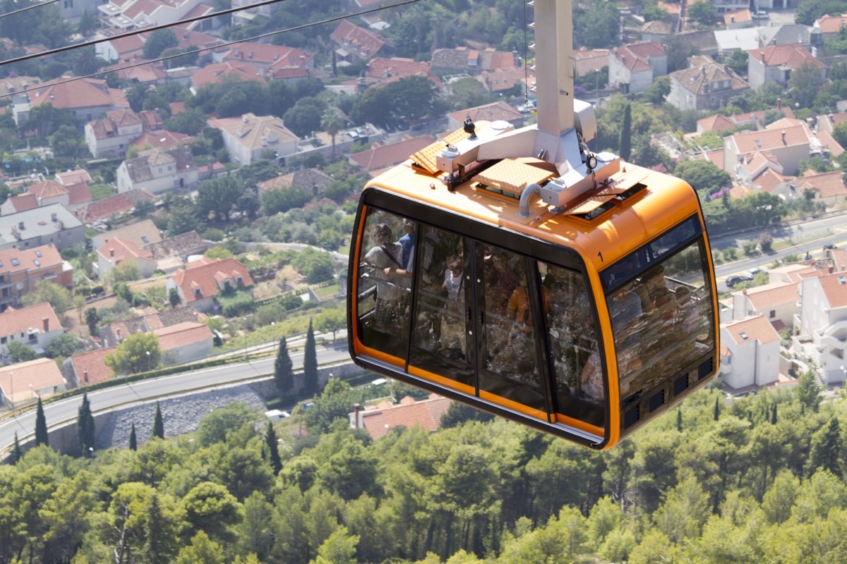 Dubrovnik cable-car cabin climbing towards the Srđ summit above the rooftops